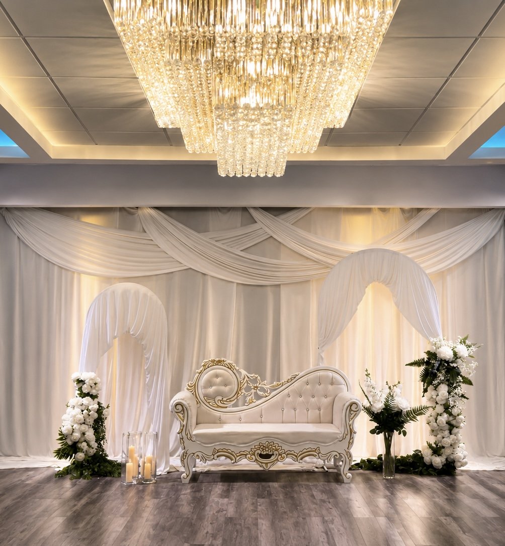 Karmel Grand Hall set with a bridal stage, white draping, florals, and crystal chandelier