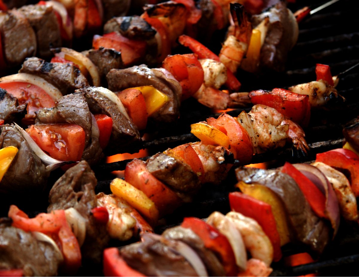 Grilled beef and shrimp kebabs with peppers and onions